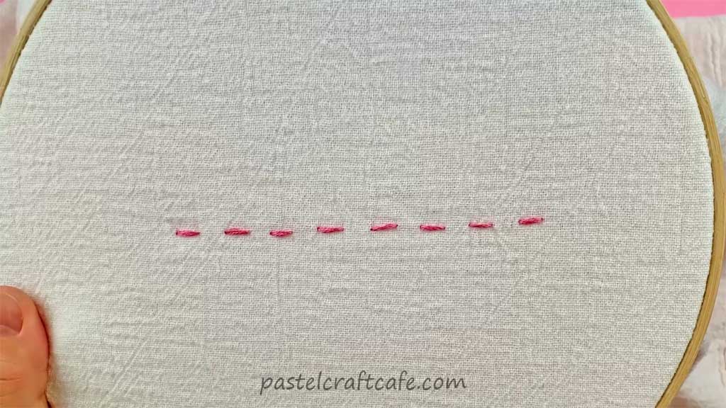 A horizontal line of the running stitch on an embroidery hoop