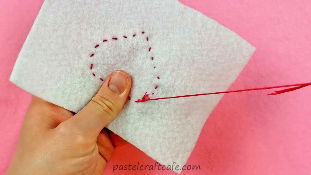 Tying a knot on the backside of the heart applique to a nearby stitch
