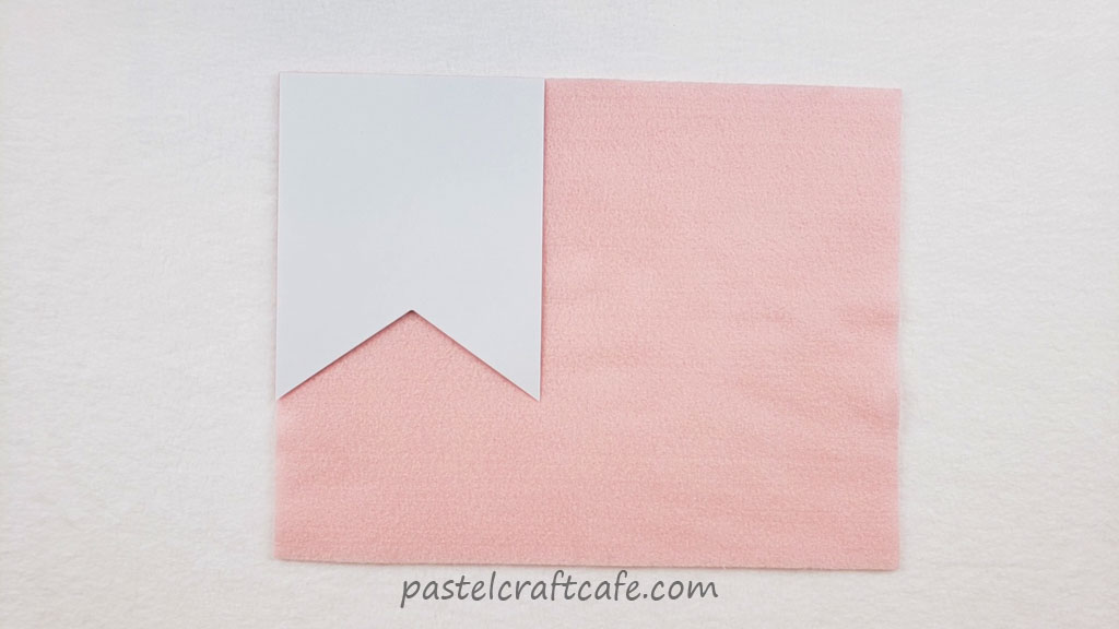 A flag shaped pattern sitting on a sheet of pink felt