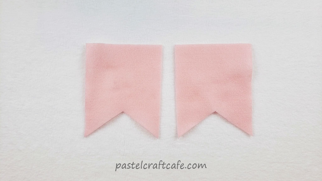 Two rectangular flags cut out from pink felt