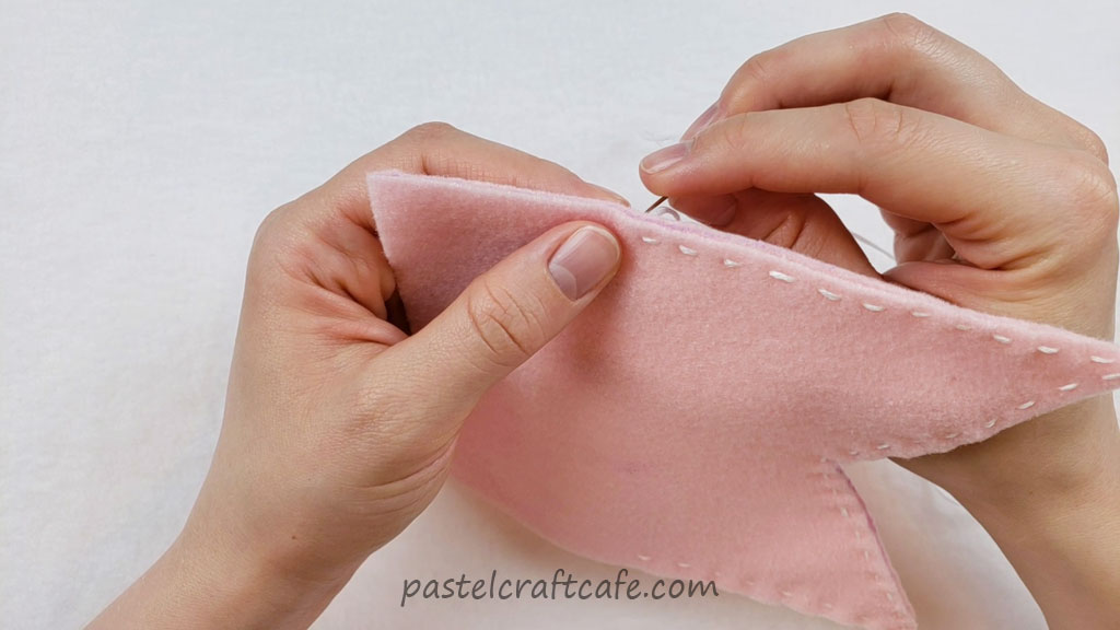 Two layers of the pink flag being sewn together using the running stitch