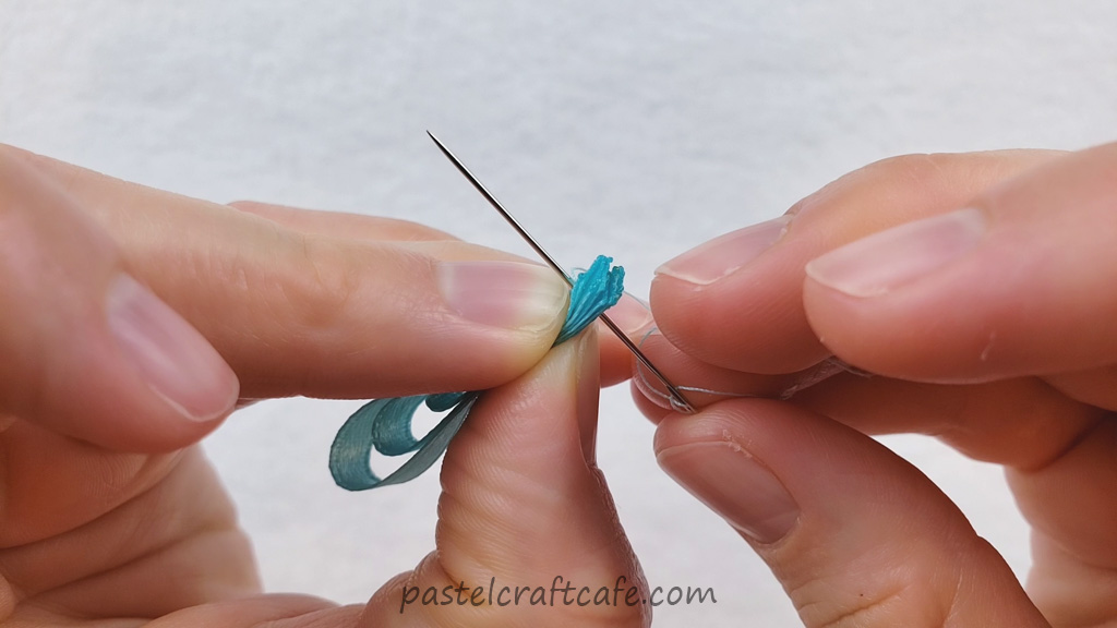 A needle going through six layers of ribbon