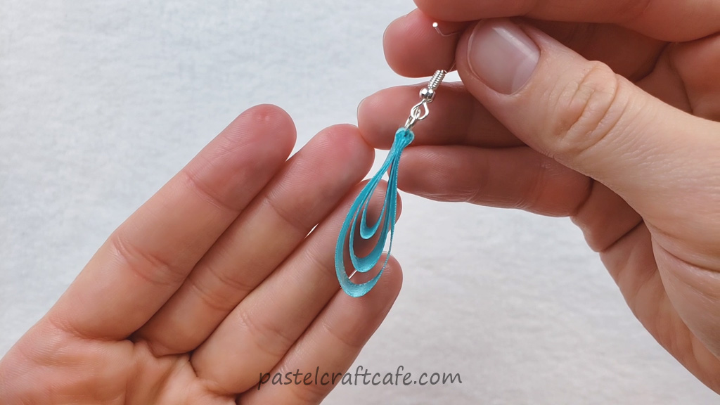 A tiered ribbon earring charm attached to a fish hook earring