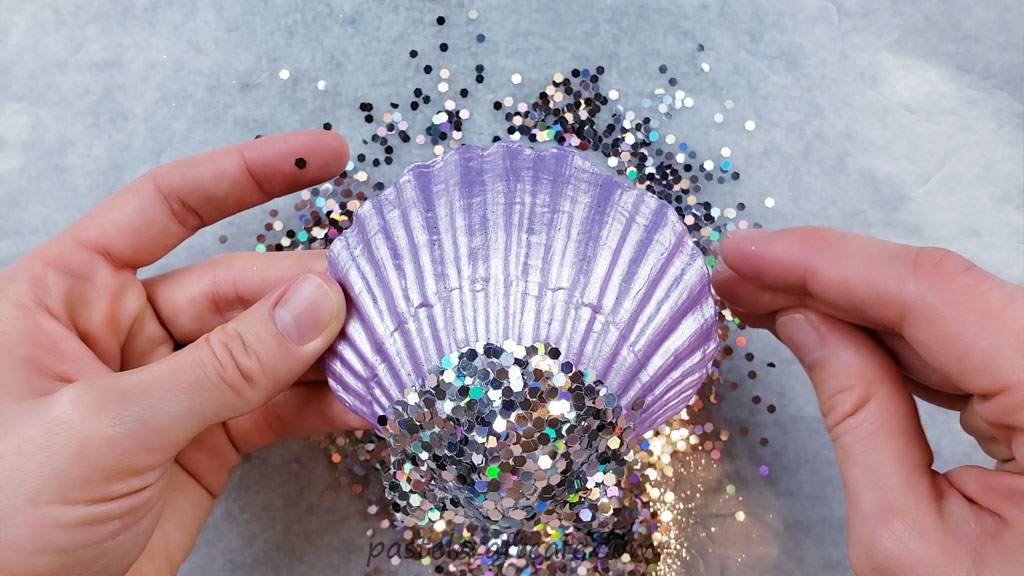 A purple seashell with chunky holographic glitter