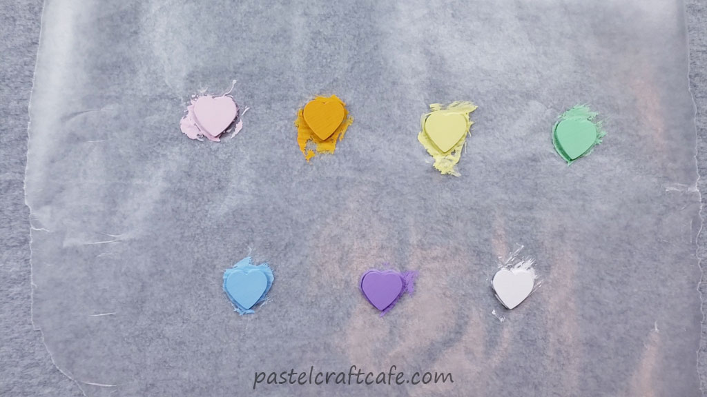 seven wooden hearts painted with different colors of acrylic paint