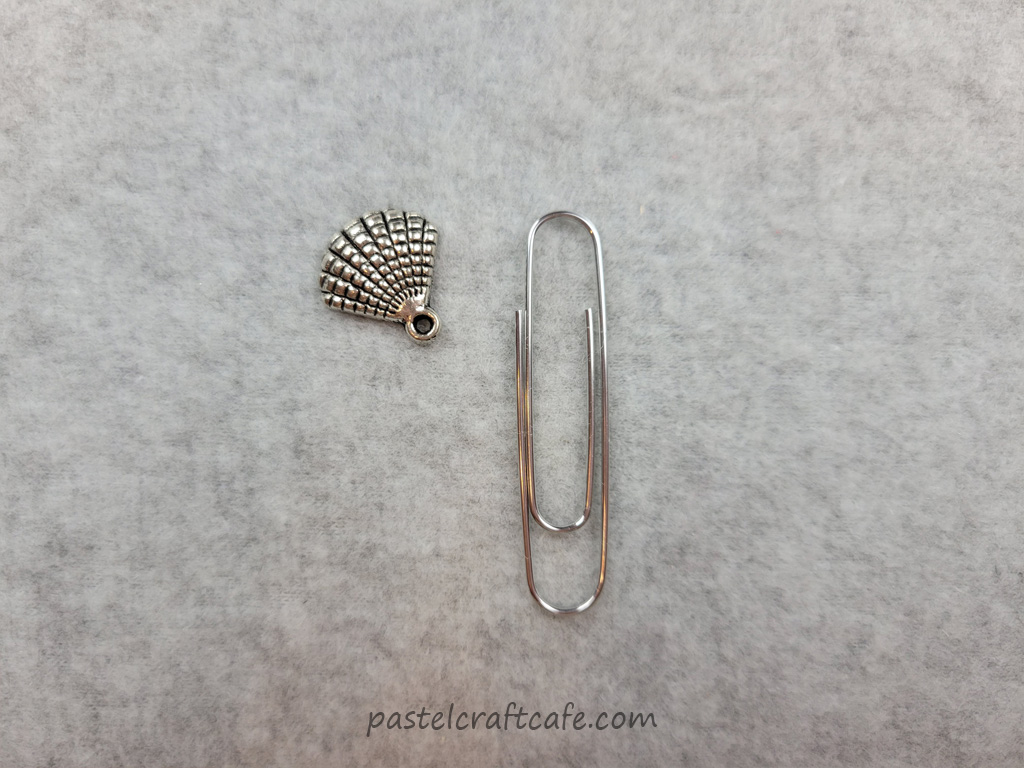 A seashell charm and a paperclip