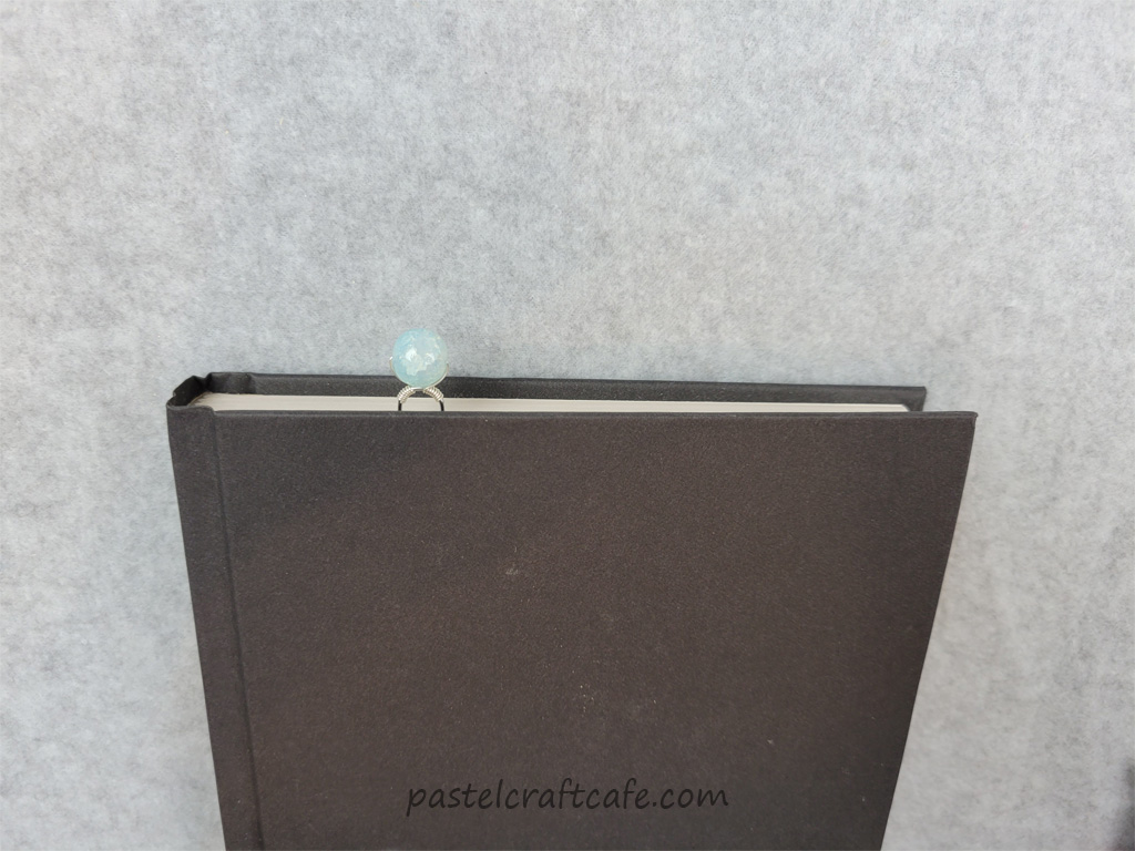 A beaded paperclip bookmark in a book