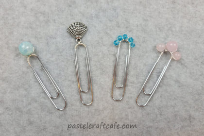 Four charm and bead paperclip bookmarks with various beads and charms attached to the top of the paperclips