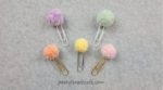 Five pom pom paperclip bookmarks in various colors