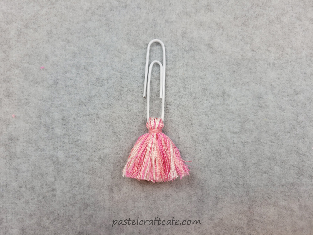 A multicolored pink tassel paperclip bookmark
