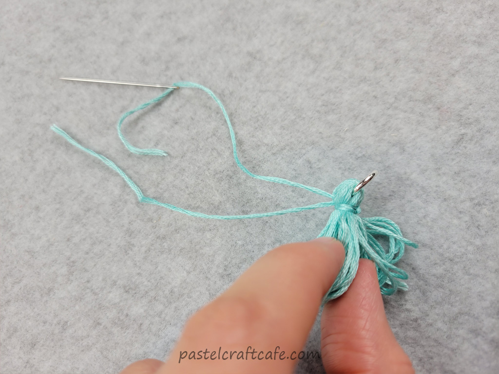Two threads that have been pulled to the other side of a tassel
