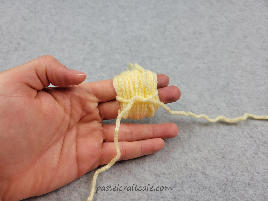A bundle of yarn around two fingers tied together with another piece of yarn