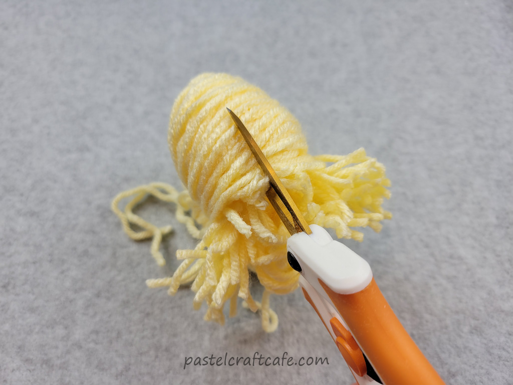 Cutting the loops on a four finger pom pom
