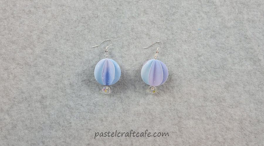 A set of 3D paper ball earrings sitting on a table