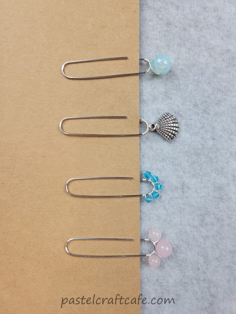 Four different beaded paperclip bookmarks attached to a piece of cardstock