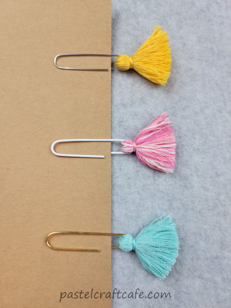 Three tassel paperclip bookmarks attached to a piece of cardstock