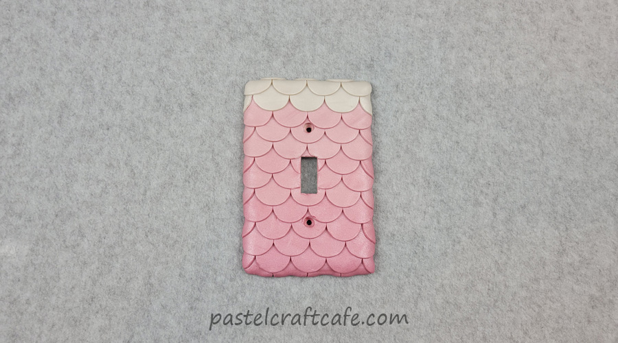A pink mermaid scale light switch cover