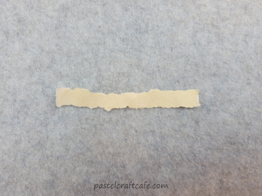 A small strip of ripped tea stained paper