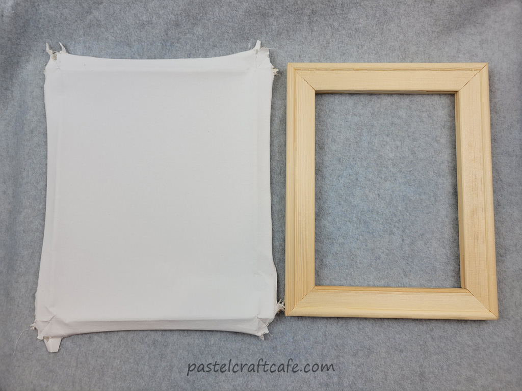 The removed canvas fabric next to the blank frame of a painting canvas