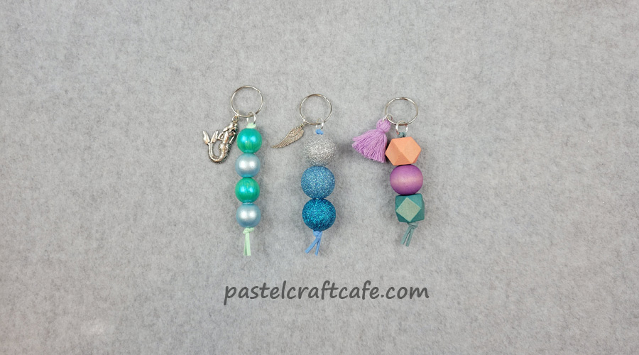 Three wood bead keychains decorated using different methods