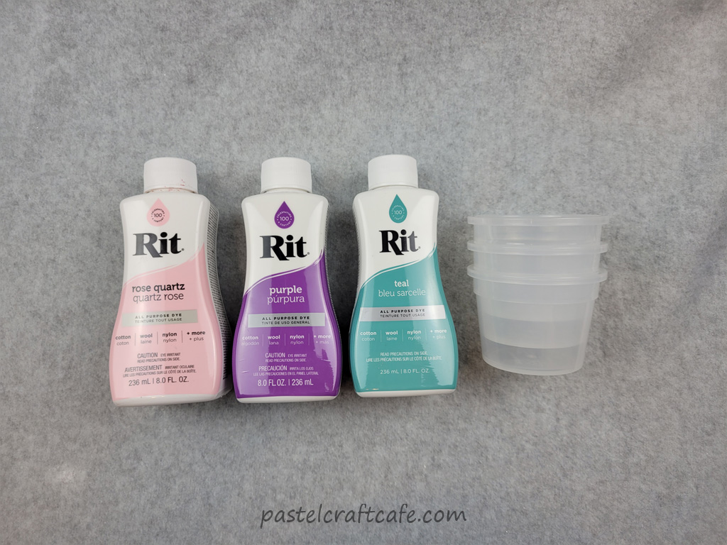 Three bottles of Rit Dye and plastic cups
