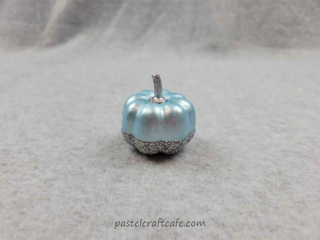 A blue craft pumpkin with silver glitter on the bottom