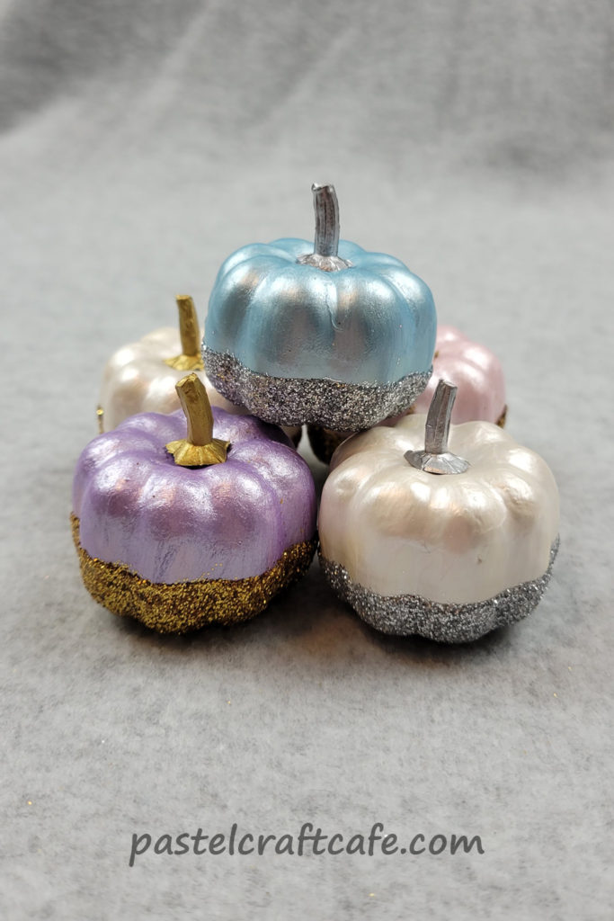 A pile of painted glitter dipped pumpkins
