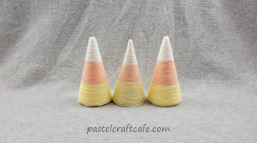 A set of three yarn wrapped candy corn cones in traditional colors