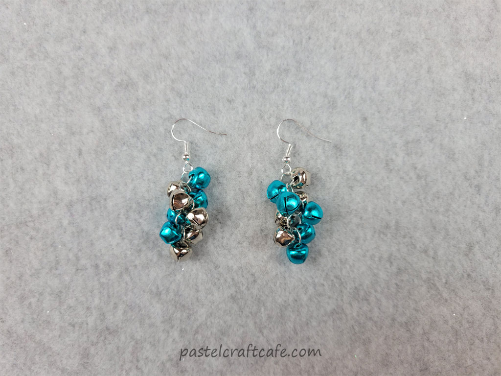 A completed pair of silver and blue jingle bell cluster earrings