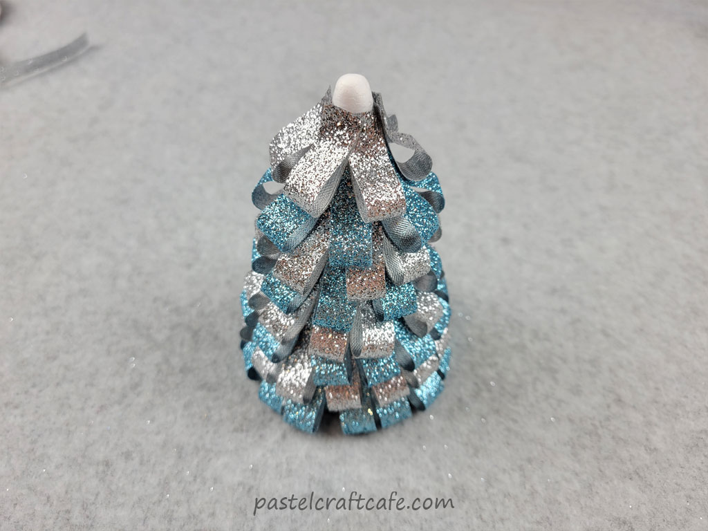 A styrofoam cone with ribbon loops pinned to it, colors alternating between blue and silver