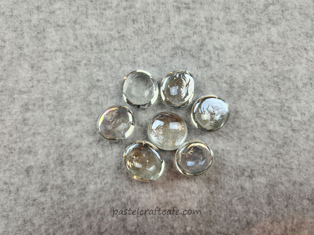 Clear glass floral gems, showing the back side with several small imperfections