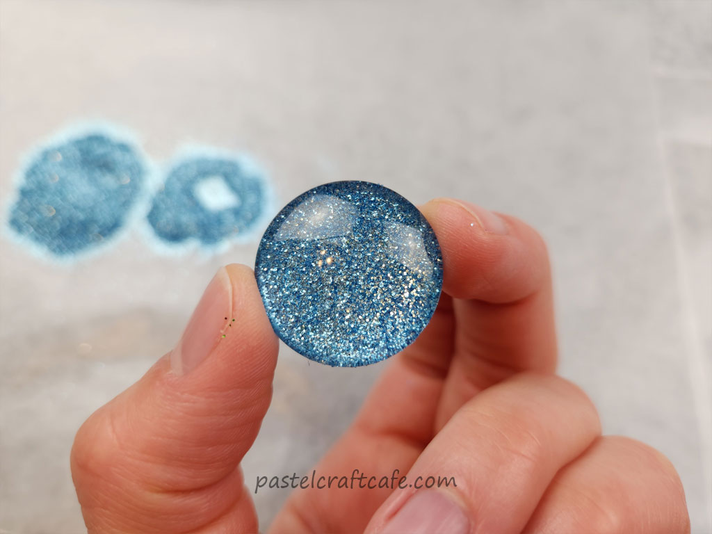 The front side of a cabochon after the second layer of glitter had been applied after the glue had dried
