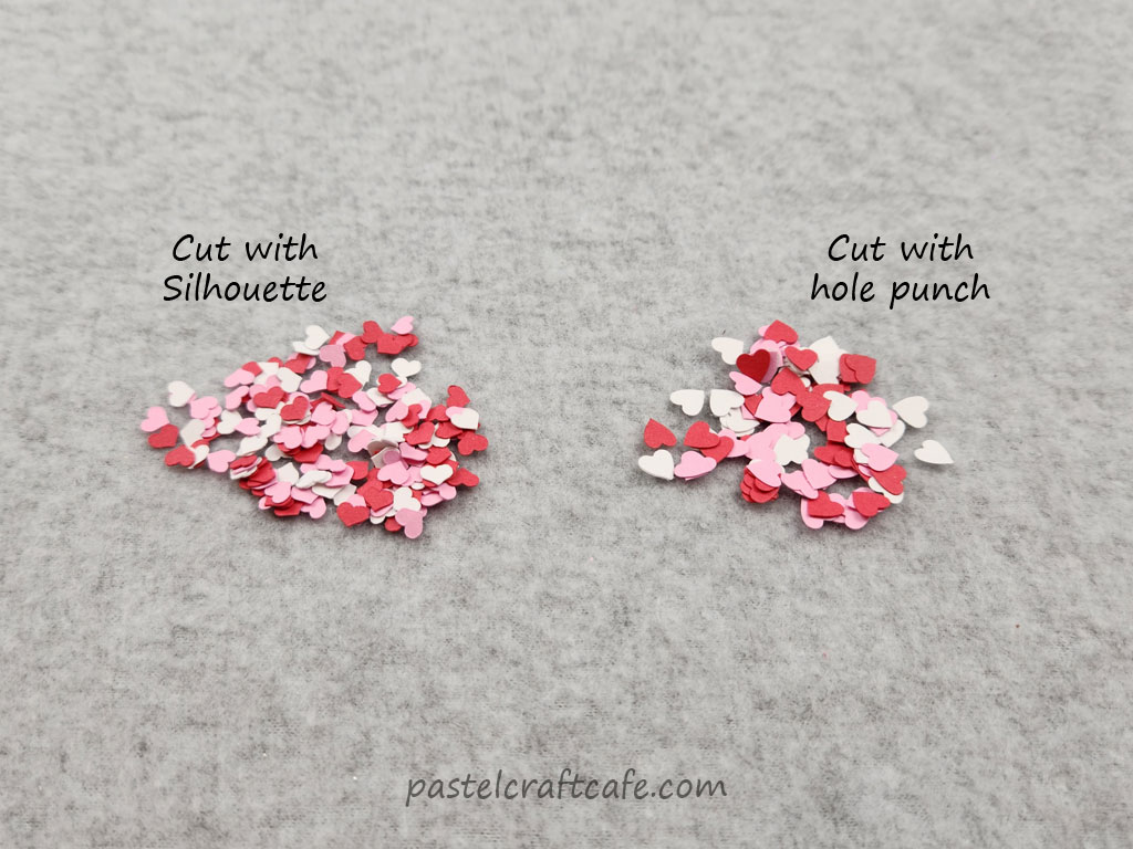Two piles of tiny paper hearts, one labeled "Cut with Silhouette" and the other labeled "Cut with hole punch"